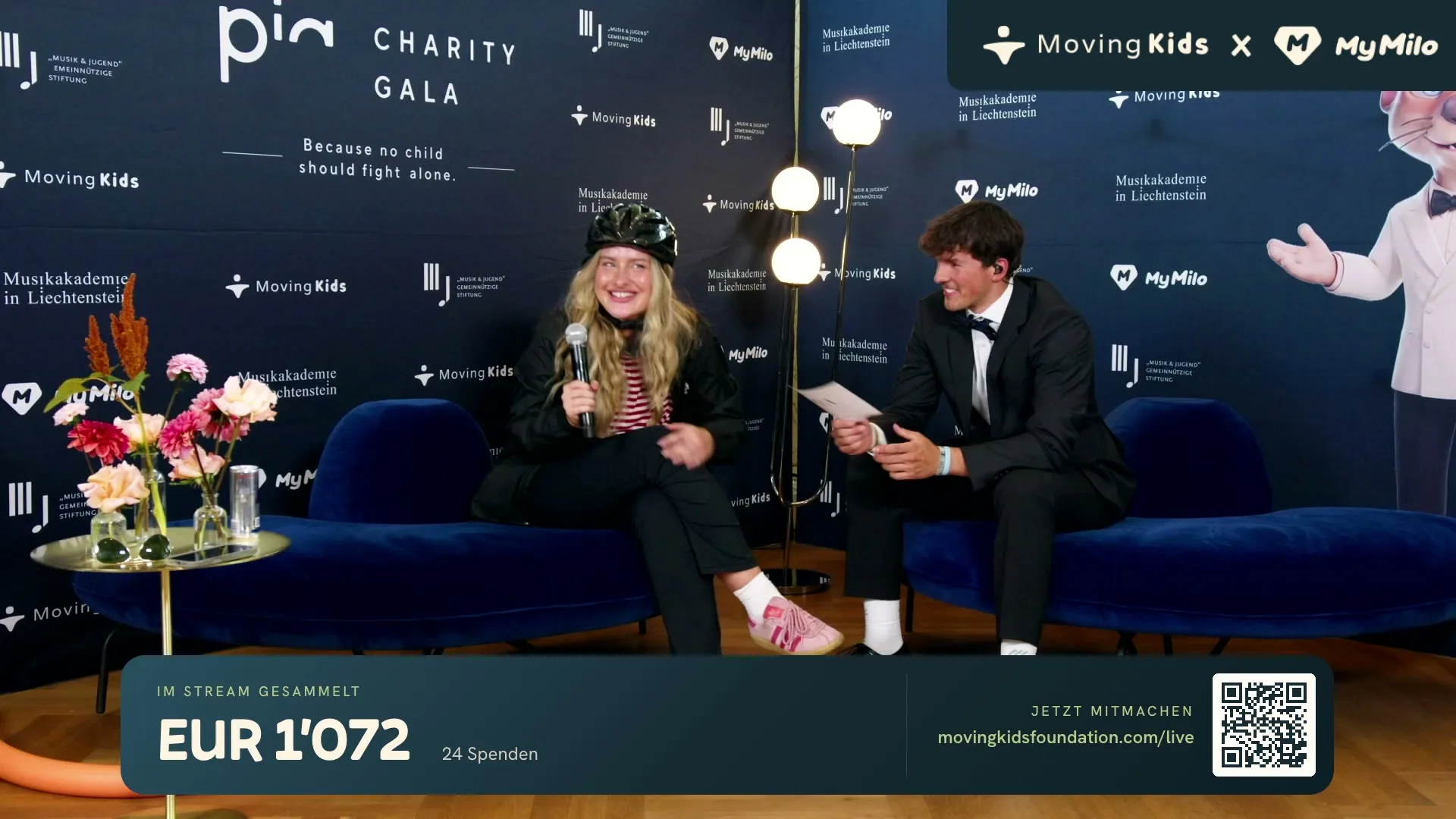 An interview on the couch at the PIA Charity Gala, in front of the gala backdrop